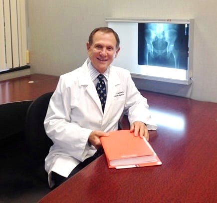 Dr. Sidney H. Levine reviewing a pelvic radiograph on a lightbox — orthopedic expert witness San Diego